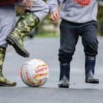 Adult and child playing football